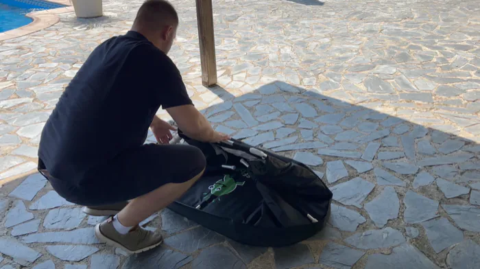 Eine Person klappt die Seiten des Eisbads samt Gestänge ein